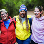 Multiracial women having fun during trekking day in to the wood – Escape to nature and travel concept