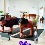 Mixed race couple practicing stretching exercise at home