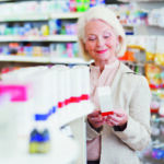 Senior woman reading package in drug store